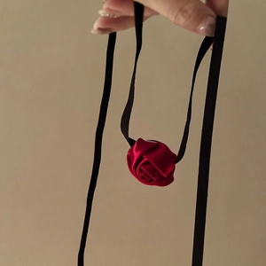 Detail of a handmade red satin rose pendant with elegant black ribbon choker ties