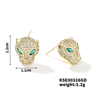 Détail des boucles d'oreilles tête de léopard dorées avec zircons blancs et verts