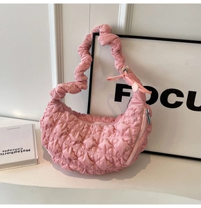 Detailed view of pink quilted cloud bag with pleated texture and crescent shape