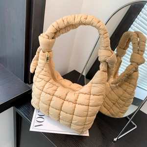 Chic beige quilted puffer tote bag with knotted handles and soft cloud-like texture