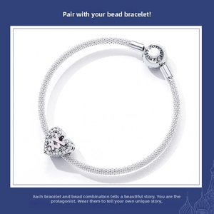 Detail of silver mesh bracelet featuring a heart pendant with pink crystals and engraving
