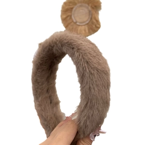 Serre-tête classique en fausse fourrure marron avec texture pelucheuse sur un fond blanc pur
