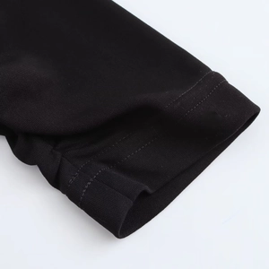 Close-up of black knitted sleeve cuff showing detailed stitching and fabric texture