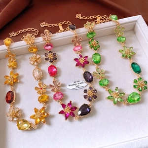 Macro detail of vintage floral crystal necklaces in gold finish with colorful gemstones