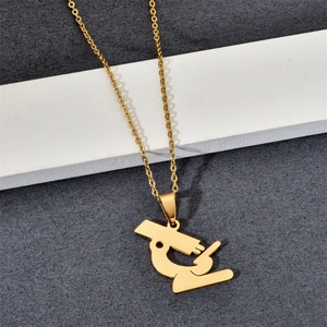 Detailed close-up of a polished gold-plated stainless steel microscope pendant necklace