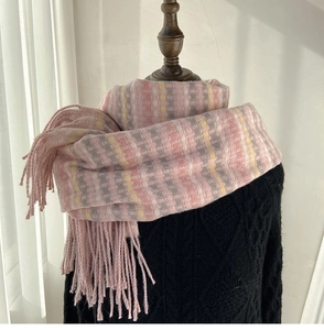 Detail shot of soft rainbow plaid pattern and tassel fringe on a thick winter scarf