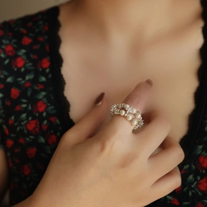 Close-up of double-layer pearl stretch ring with zircon star detail on model's finger