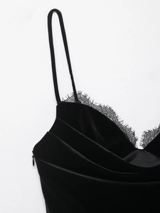Detailed close-up of black velvet dress featuring delicate lace trim and v-neckline design
