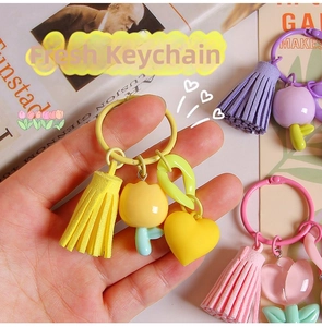 Close-up of pastel resin tulip keychains with soft tassels and heart charms