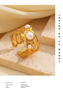 Macro detail of gold wavy multi-layer ring band with three white pearls on stone