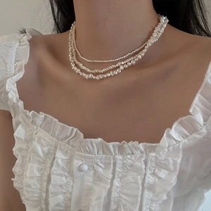Detailed view of triple-layered freshwater pearl necklace with baroque style pearls