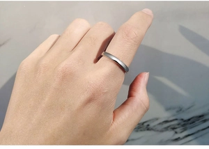 Close-up of minimalist silver spinning ring on finger with polished finish