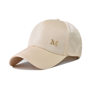 Détail de la casquette satin champagne avec logo M métallique et visière mate