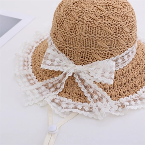 Girl's straw sun hat with white lace trim, large bow and adjustable chin strap