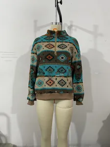 Dettaglio pullover in pile con stampa geometrica tribale, collo alto e zip