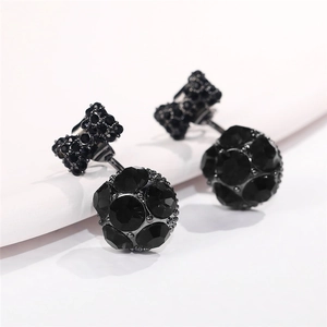 Detalle macro de pendientes de lazo con cristales negros y pavé de piedras brillantes