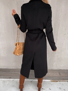 Detailed back view of a long black wool coat with waist tie and back slit design
