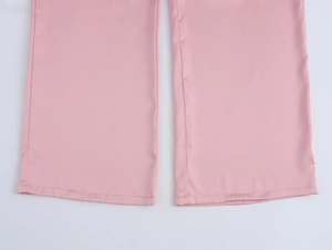 Détail du bas de pantalon rose avec coutures soignées et tissu au tissage uni