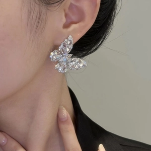Sparkly cubic zirconia butterfly stud earrings in silver on a female model