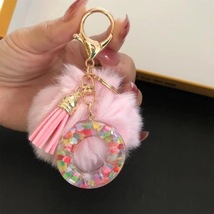 Detailed shot of pink pom-pom keychain with colorful heart sequins and golden clasp