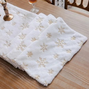 White faux fur Christmas table runner with gold sequin snowflakes on a wooden table