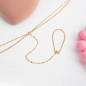 Minimalist 18k gold plated slave bracelet with zircon accents and fine chain on white background