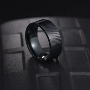 Close-up of 8mm men's black grooved titanium steel ring with mirror finish inner band