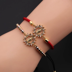 Detail of multi-color zircon sunburst charms with Virgin Mary on handmade woven bracelets