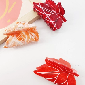 Minimalist leaf-shaped hair clips in red and orange with elegant marble patterns