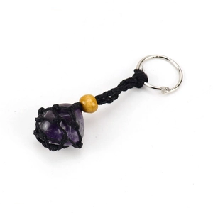 Detail of raw purple crystal stone in black woven net keychain with a brown wooden bead