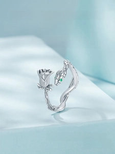 Macro shot of S925 silver ring featuring rose and snake design with green gemstone eyes