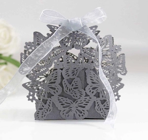 Detail of silver laser-cut butterfly wedding candy box with a silk ribbon bow