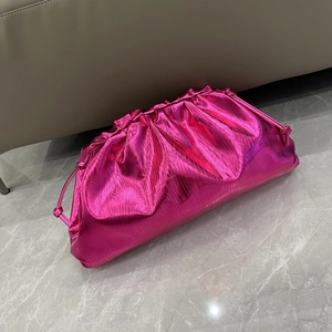 Macro shot of metallic pink pleated cloud clutch bag with smooth texture and shiny finish