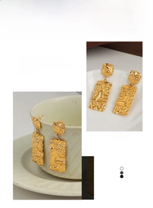 Detail of gold rectangular drop earrings with hammered texture and fluid metal effect