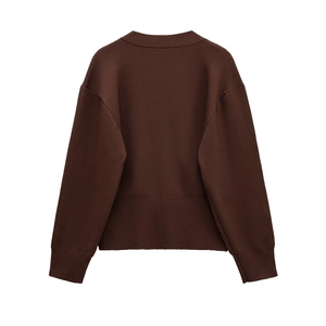 Detail view of the back of a dark brown knit cardigan with ribbed cuffs and hem
