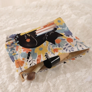 Corduroy makeup bag featuring black cat and floral prints with brushes inside