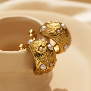 Detail of vintage 18k gold plated hoop earrings with pearls and star engraving