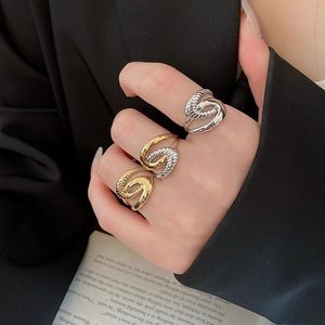 Detail showing mixed metal starfish texture rings worn against a black suit background
