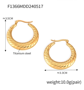 Close-up of gold-plated titanium steel hoop earrings featuring diagonal twisted texture
