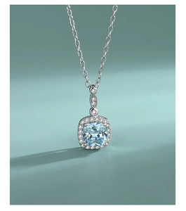 Detail of S925 silver heart necklace with blue gemstone and micro-paved crystal border