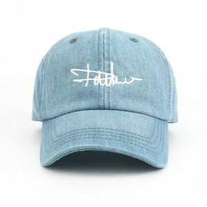 Detailed view of light blue denim baseball cap with white embroidery and stitching