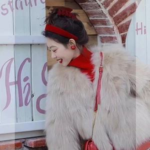 Elegant ivory faux fur coat paired with red enamel ball earrings and festive accessories