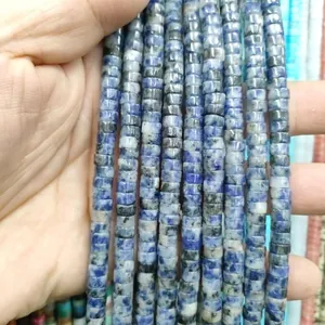 Close-up of blue and white natural stone spacer beads with cylindrical texture