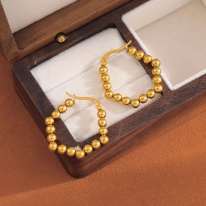 Polished gold beaded hoop earrings in a vintage square shape on a velvet display