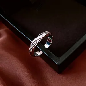 Twisted silver ring with zircon stones displayed on a black velvet box edge