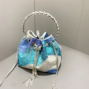 Dettaglio borsa a secchiello con strass sfumati blu, manico in metallo e catena