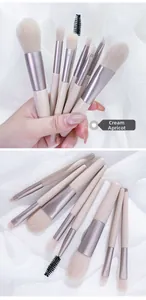 Detail view of 8-piece creamy apricot mini makeup brush set on white fabric