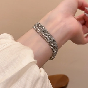 Close-up of elegant multi-layered silver bead chain bracelet on a woman wrist