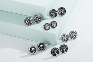 Detailed close-up of vintage silver earrings featuring Tree of Life and Hamsa Hand motifs