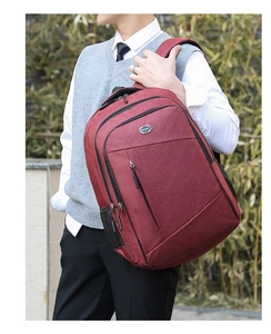 Closer view of burgundy Oxford fabric backpack with multi-compartment storage zippers